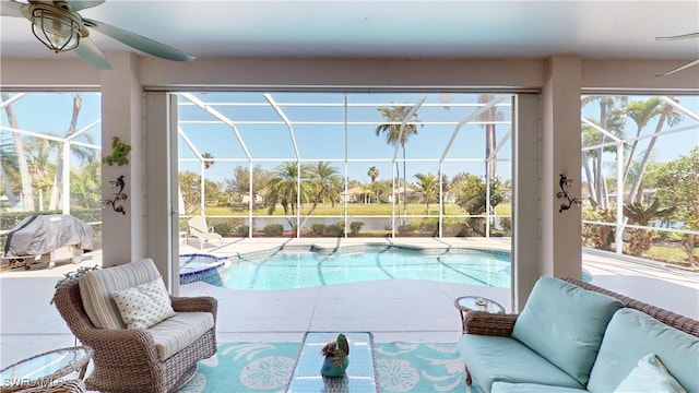 view of pool with a ceiling fan, a pool with connected hot tub, glass enclosure, outdoor lounge area, and a patio area