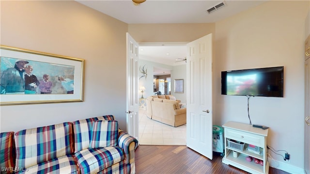 living area featuring visible vents and wood finished floors