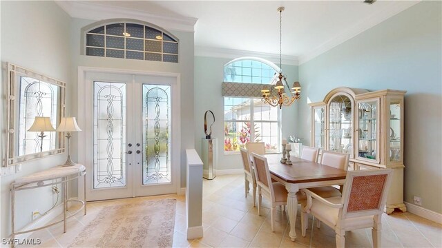 foyer entrance featuring french doors, baseboards, a chandelier, and crown molding