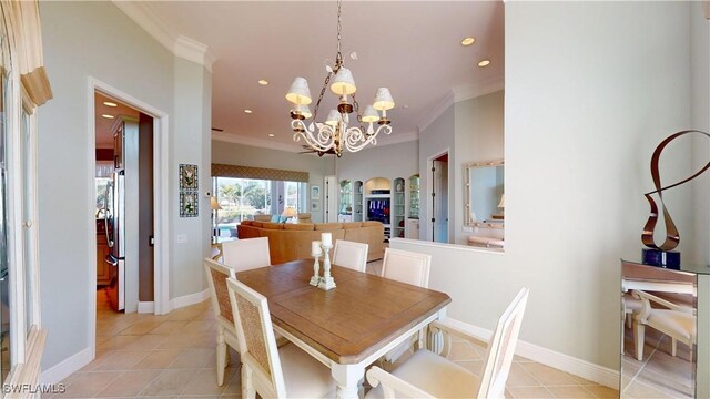 dining room featuring light tile patterned floors, baseboards, an inviting chandelier, and ornamental molding