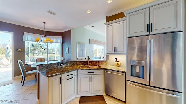 kitchen featuring visible vents, light tile patterned floors, a peninsula, stainless steel appliances, and a sink