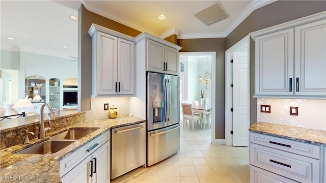 kitchen featuring visible vents, crown molding, appliances with stainless steel finishes, light tile patterned flooring, and a sink
