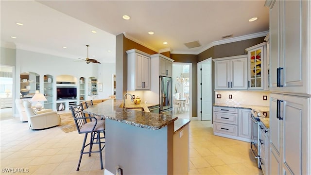 kitchen featuring a peninsula, stone countertops, stainless steel appliances, a kitchen breakfast bar, and open floor plan