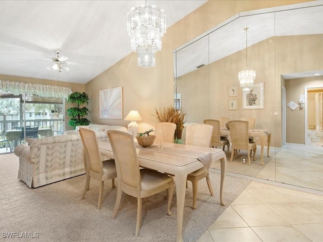 dining space featuring lofted ceiling, ceiling fan with notable chandelier, and light tile patterned flooring