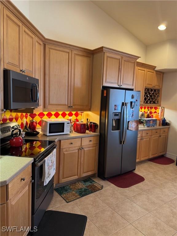 kitchen featuring light tile patterned floors, recessed lighting, light countertops, decorative backsplash, and appliances with stainless steel finishes