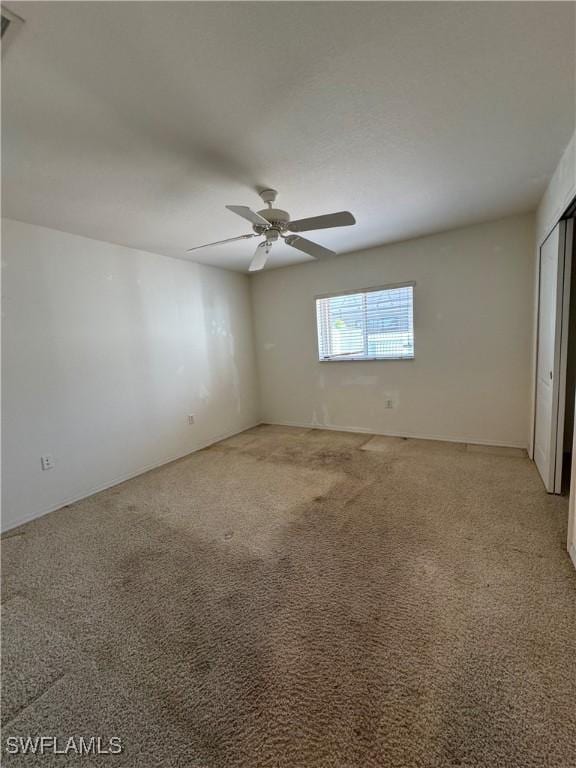 spare room featuring carpet and ceiling fan