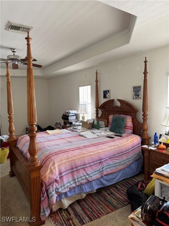 carpeted bedroom with a raised ceiling and visible vents