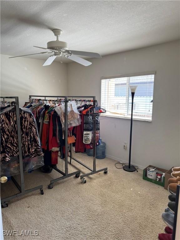 workout room featuring carpet, ceiling fan, and a textured ceiling