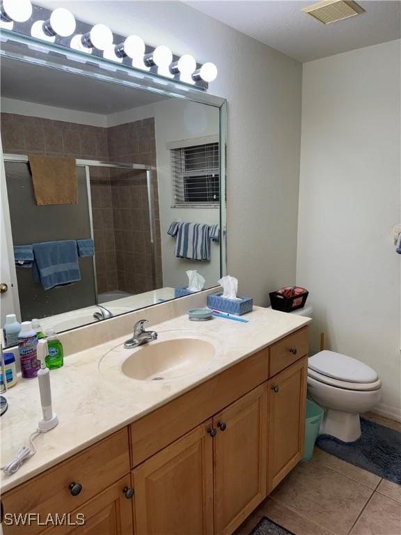 bathroom featuring a stall shower, visible vents, toilet, tile patterned flooring, and vanity