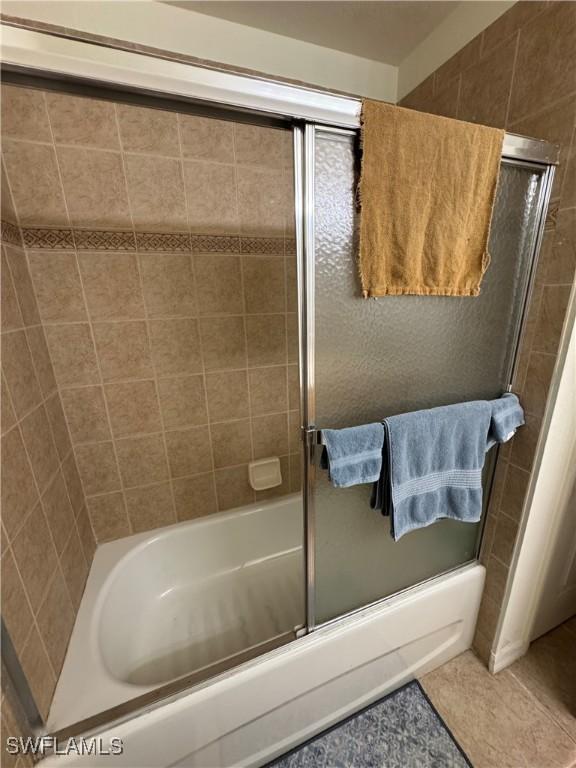 bathroom featuring enclosed tub / shower combo and tile patterned floors