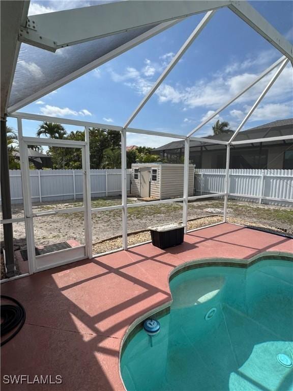 view of swimming pool with a fenced backyard, a shed, a fenced in pool, and an outbuilding