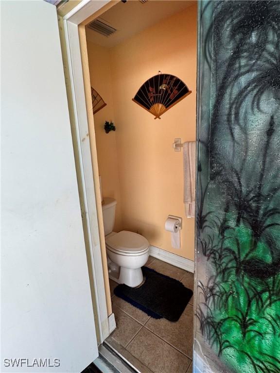 bathroom featuring toilet, tile patterned flooring, visible vents, and baseboards