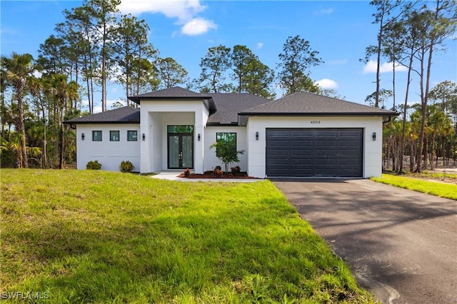 prairie-style home with a garage, stucco siding, aphalt driveway, and a front yard