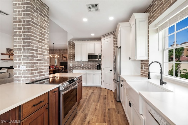 kitchen with visible vents, white cabinets, appliances with stainless steel finishes, light countertops, and a healthy amount of sunlight