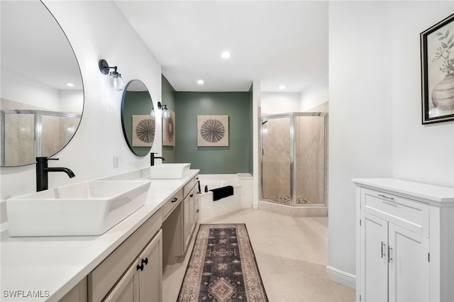 full bath with a stall shower, a sink, recessed lighting, and double vanity