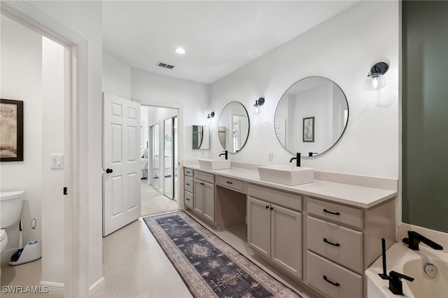 full bath featuring visible vents, a sink, toilet, and double vanity