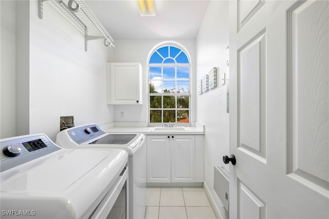 washroom featuring separate washer and dryer, light tile patterned flooring, a sink, and cabinet space