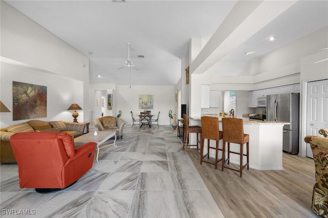 living room with visible vents, ceiling fan, light wood-style flooring, high vaulted ceiling, and recessed lighting