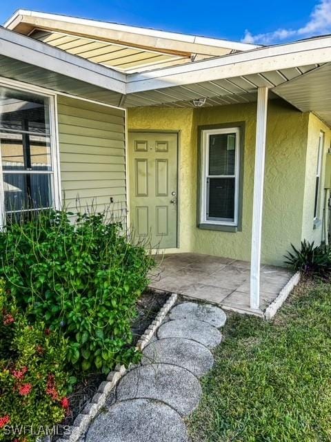 doorway to property featuring a patio area and stucco siding