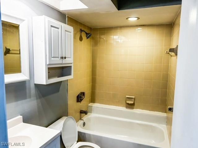 bathroom with bathing tub / shower combination, vanity, and toilet