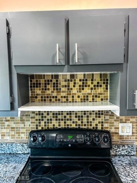 room details with black electric range, tasteful backsplash, and gray cabinetry