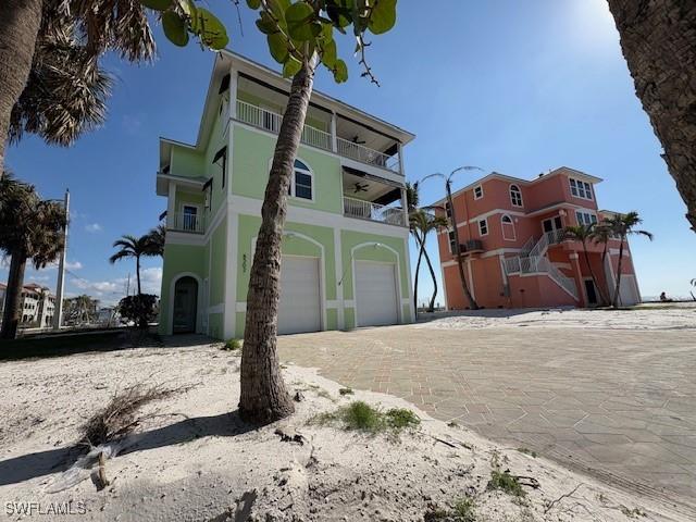 view of home's exterior with driveway, an attached garage, and a balcony
