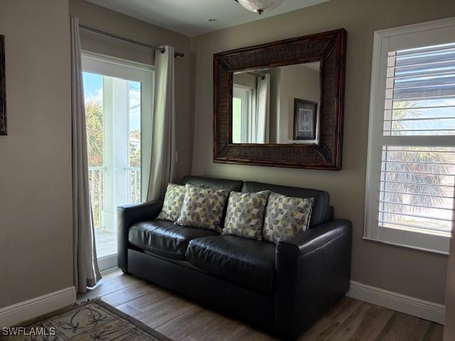 living area featuring baseboards and wood finished floors