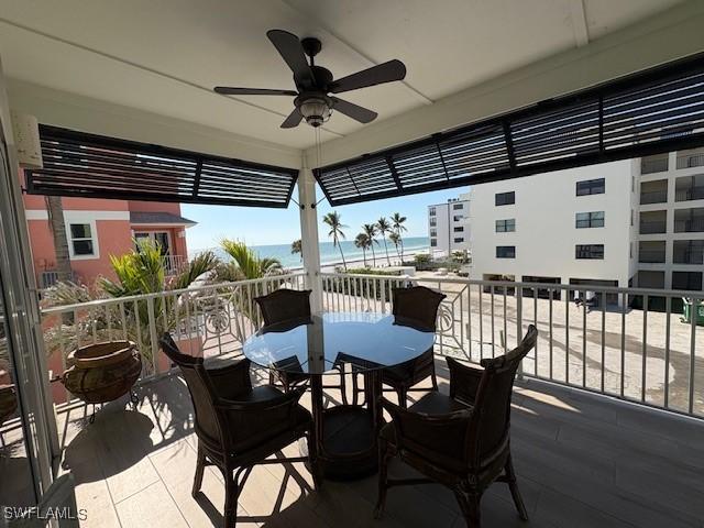 view of patio / terrace featuring a water view, a ceiling fan, and a balcony