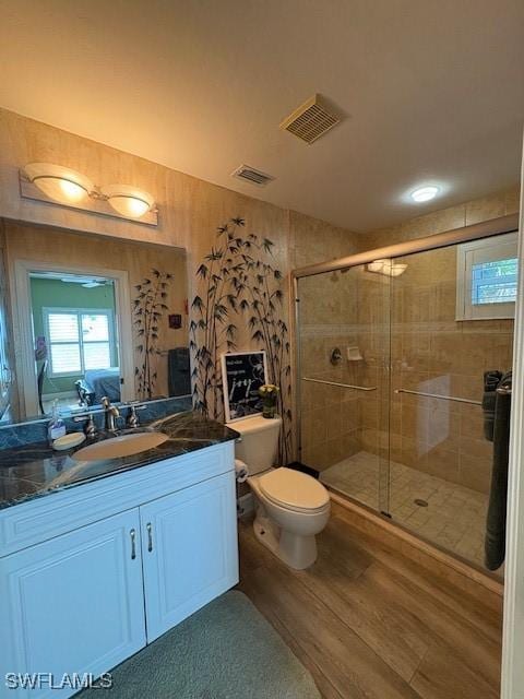 bathroom with a stall shower, visible vents, and wood finished floors