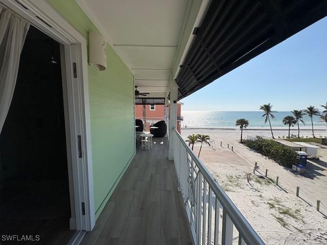 balcony featuring a beach view and a water view