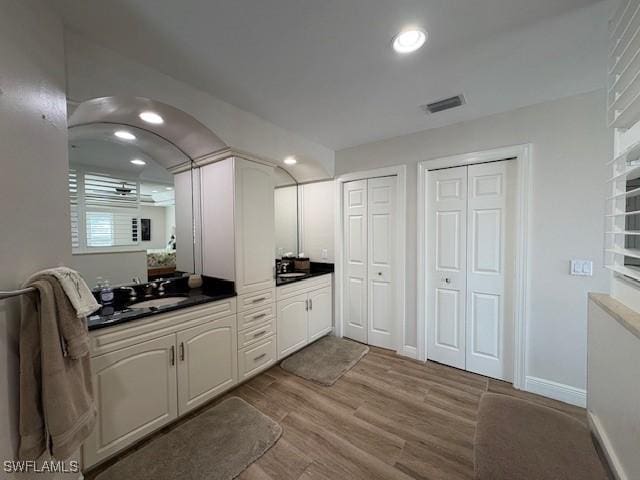 full bath with a closet, recessed lighting, visible vents, vanity, and wood finished floors