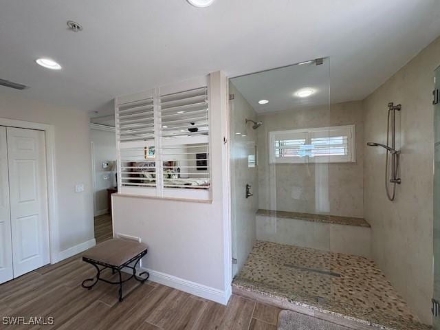 bathroom with wood finished floors, a walk in shower, visible vents, baseboards, and recessed lighting