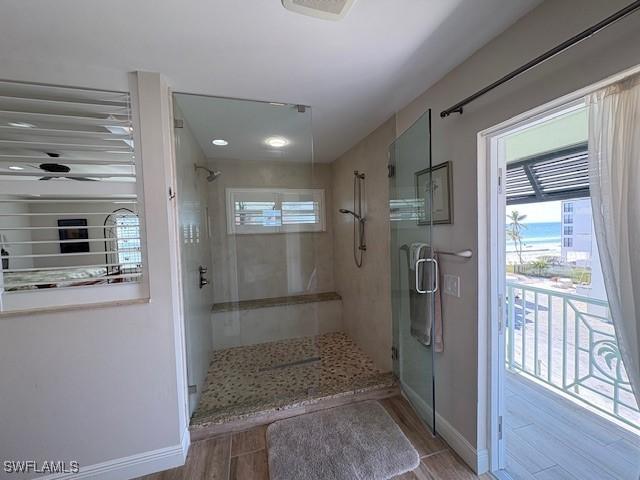 bathroom featuring baseboards, wood finished floors, a stall shower, and visible vents