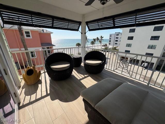 balcony with a water view and a ceiling fan