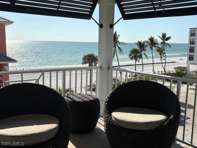 balcony featuring a water view and a view of the beach