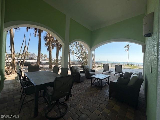 view of patio / terrace featuring a water view, an outdoor hangout area, outdoor dining area, and an AC wall unit