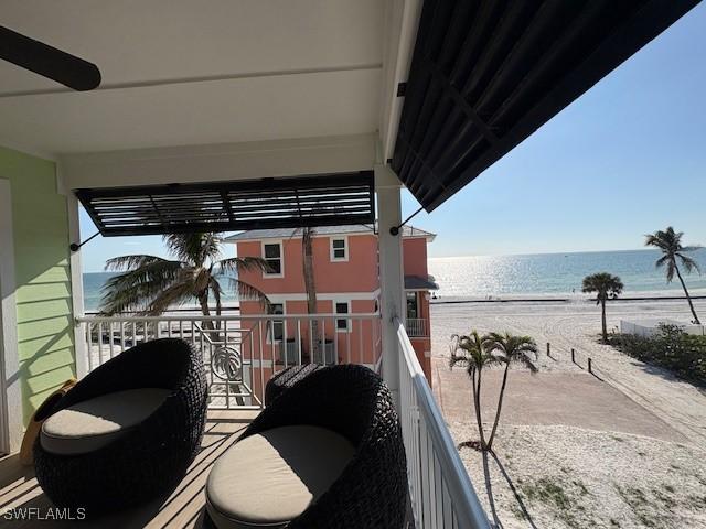 balcony with a water view and a view of the beach