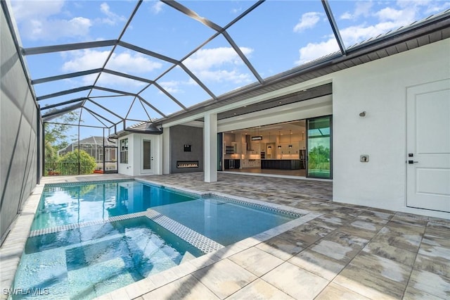 view of swimming pool with glass enclosure, a pool with connected hot tub, and a patio area