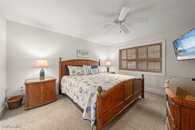 bedroom with ceiling fan, baseboards, and light carpet