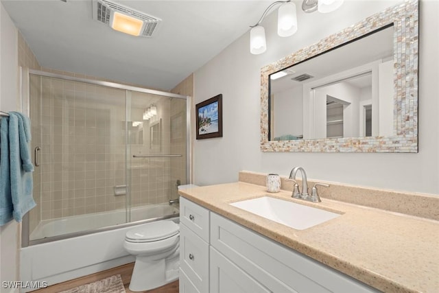 bathroom with visible vents, toilet, vanity, and wood finished floors