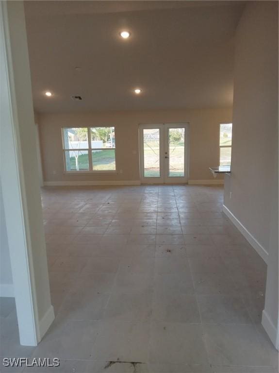 empty room featuring baseboards, french doors, and recessed lighting