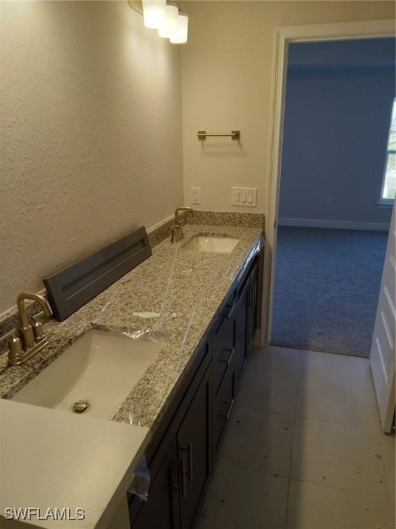 full bathroom featuring double vanity, tile patterned flooring, and a sink