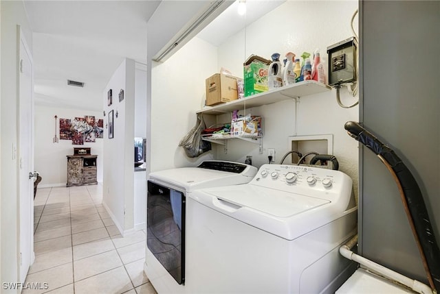 washroom with light tile patterned floors, visible vents, separate washer and dryer, laundry area, and baseboards