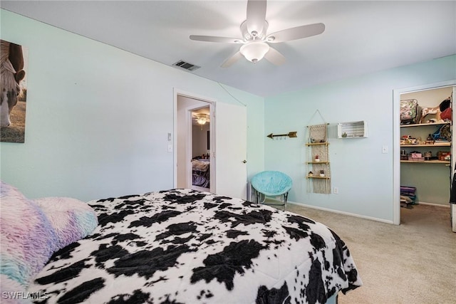 bedroom with visible vents, a spacious closet, light carpet, ceiling fan, and baseboards