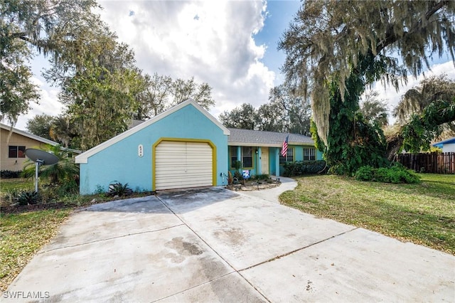 view of front of house featuring a garage, driveway, a front lawn, and stucco siding