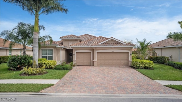 mediterranean / spanish-style house featuring decorative driveway, a tile roof, stucco siding, an attached garage, and a front lawn