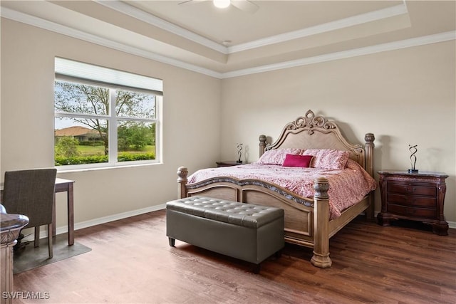 bedroom featuring a tray ceiling, dark wood-type flooring, and baseboards