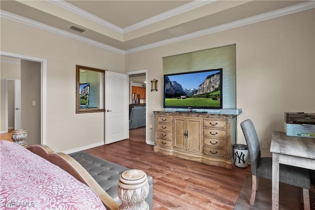 bedroom featuring ornamental molding, wood finished floors, visible vents, and baseboards