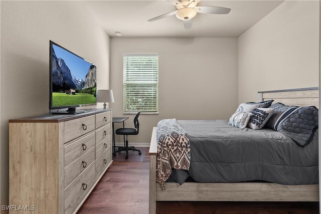 bedroom with dark wood-style flooring, ceiling fan, and baseboards