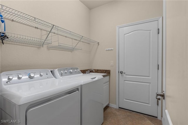 laundry area featuring cabinet space, light tile patterned flooring, a sink, and independent washer and dryer